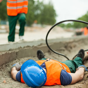 A man lying on the ground with a hose, depicting a work-related death. - Cardinal Law Partners.