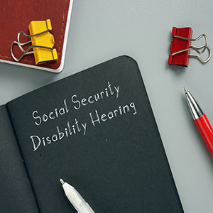 Notebook with 'Social Security Disability Hearing' written on it, symbolizing SSD hearing preparation.