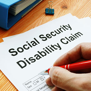 Hand with pen signing 'Social Security Disability Claim' form for North Carolina law.